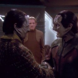 TAIN: So, you're a tailor now. Is this one of your creations?  GARAK: A minor example of my work, yes.  TAIN: I don't think I like the neckline.  GARAK: Well you always did have a keen sense of fashion, but you seem to have let it go along with your once trim figure.  